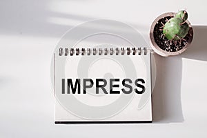 The word of IMPRESS on a notebook photo