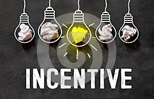 the word Incentive on a black background and a bright light bulb photo
