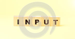Word input with small wooden blocks on yellow background