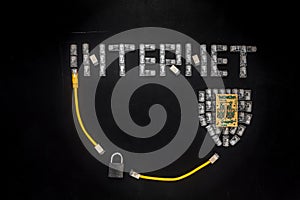 Word `Internet`, shield made of connectors RJ45 and padlock. Yellow patch cords composition isolated over the black scratched boa