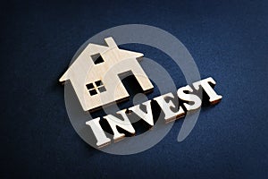 Word Invest and model of home. Real Estate Investment concept