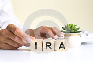 The word IRA, spelt on wooden cubes with letters over a white background IRA - short for individual retirement account