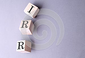 Word IRR on wooden block on the grey background