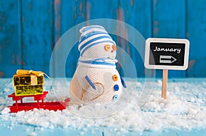 Word January written on direction sign and Snowman