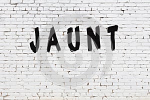 Word jaunt painted on white brick wall