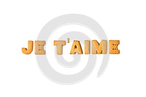 The word JE T`AIME or I LOVE YOU in French spelled with alphabet shaped biscuits on white background