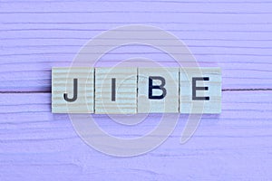 word jibe from small gray wooden letters