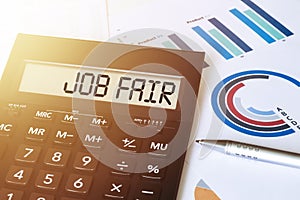 Word JOB FAIR on calculator. Business and finance concept