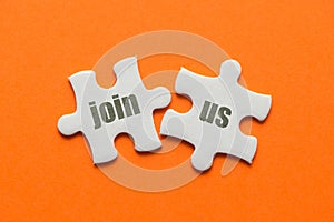 The word Join Us! on two matching puzzle on orange background