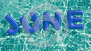 Word `JUNE` shaped inflatable swim ring floating in a refreshing blue swimming pool