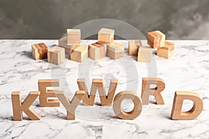 Word KEYWORD made of wooden letters on marble table