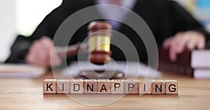 Word Kidnapping made of wooden cubes against female judge