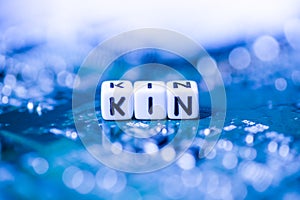 Word KIN formed by alphabet blocks on mother cryptocurrency photo