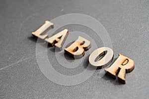 Word labor on gray background with copy space and space for text, wooden vintage letters