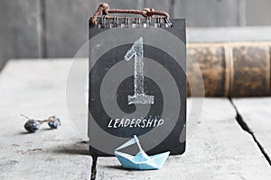 Word Leadership, Number One and a paper boat
