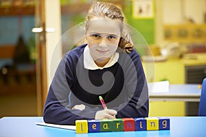 Word Learning Spelt In Wooden Blocks With Pupil Behind