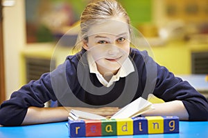 Word Learning Spelt In Wooden Blocks With Pupil Behind