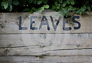 The word leaves in large black hand painted lettering in compost bin photo