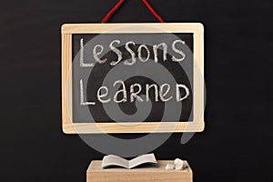 Word lessons learned written on miniature chalkboard