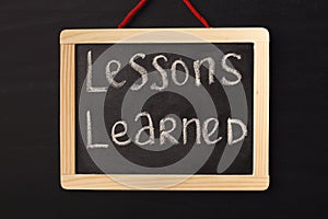 Word lessons learned written on miniature chalkboard photo