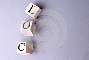 Word LOC on wooden block on the grey background