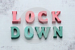 Word LOCKDOWN laid out of wooden letters on gray background