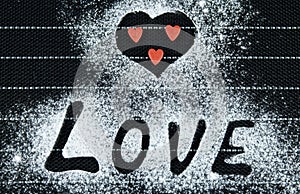 Word love on a black background. Three red hearts. Sprinkle with flour. valentines day concept. Copyspace love concept