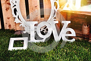 The word love composed of white letters on the sunset. Decoration proposal. Planning of wedding, celebrations in exterior.