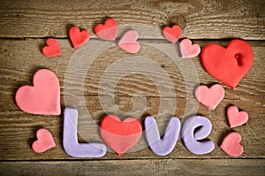 Word Love composition on the wooden board with hearts