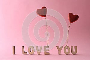 Word love and hand holding heart on pink background