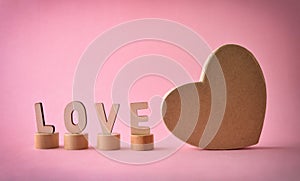 Word love and heart shaped box on pink background