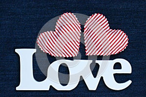 The word Love with hearts on blue denim backdrop