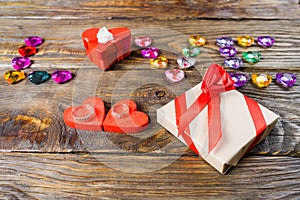 Word love laid out young hearts, two boxes for a gift in the shape of hearts and decorative hearts on wooden background.