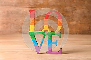 Word LOVE made of rainbow letters on wooden table. LGBT concept