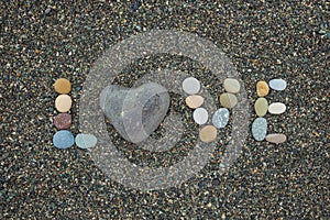 Word love made from stones on sandy beach.