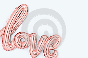 Word Love. Pink foil inflatable balloon on a blue background.