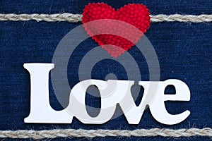 The word Love with red heart and rope border on denim