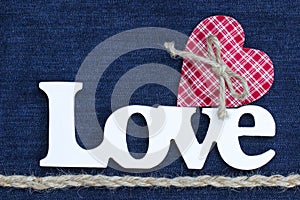 The word Love with red heart and rope border on denim background
