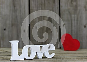 The word Love with red heart in wooden background