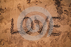 The word LOVE in the sand on the beach. Words on beach sand. Love on a tropical island. Volcanic sand