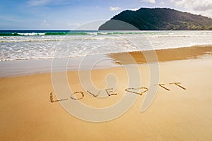 Word Love TT Trinidad and Tobago written on the beach sand in Maracas Bay Beach