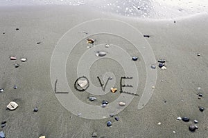 Word Love on wet beach sand