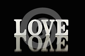 Word love, wooden letters on black background