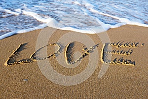 Word LOVE written on the sand at the beach
