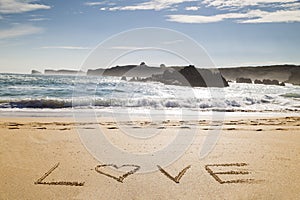 Word love written in the sand of a beautiful beach