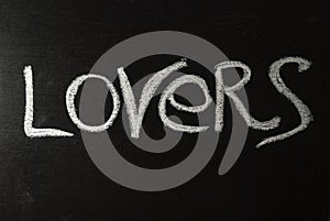 The word lovers written in white chalk on a black chalkboard