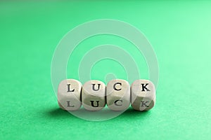 Word LUCK made with wooden cubes on green background
