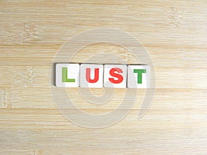 Word Lust on wood background