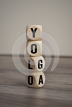 Word made of wooden blocks, cubes and dice with yolo and yoga