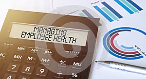 Word Managing Employee Health on calculator. Business and finance concept